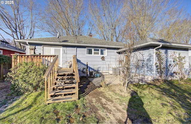 rear view of property featuring a yard and a deck