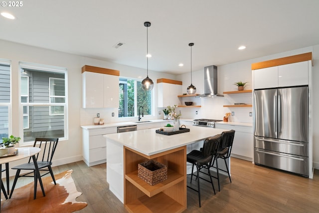 kitchen with wall chimney exhaust hood, open shelves, white cabinets, stainless steel appliances, and decorative backsplash