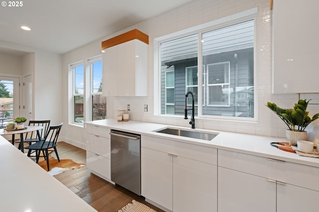kitchen with dishwasher, white cabinetry, a sink, and dark wood-style floors