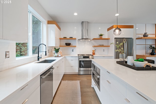 kitchen featuring wall chimney exhaust hood, modern cabinets, open shelves, appliances with stainless steel finishes, and a sink