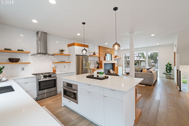 kitchen with white cabinets, open shelves, modern cabinets, wall chimney range hood, and stainless steel appliances