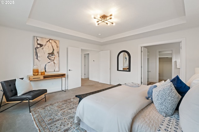 bedroom featuring a tray ceiling and carpet flooring