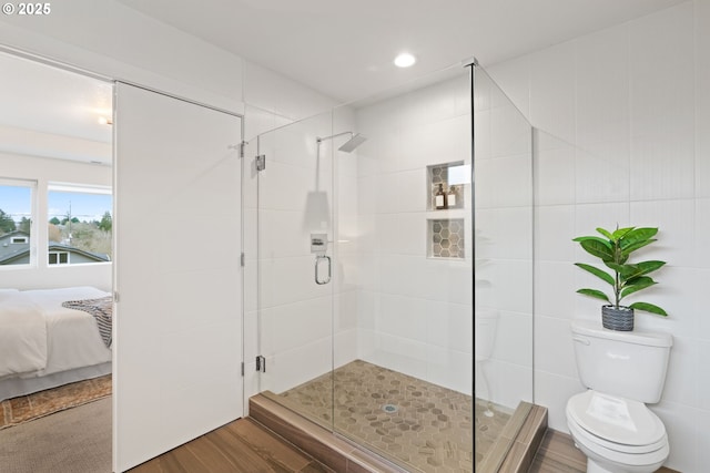 full bath with toilet, recessed lighting, connected bathroom, wood finished floors, and a stall shower