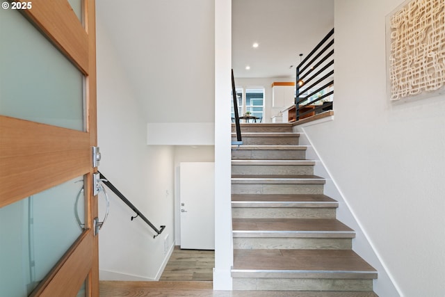 stairs with recessed lighting and wood finished floors