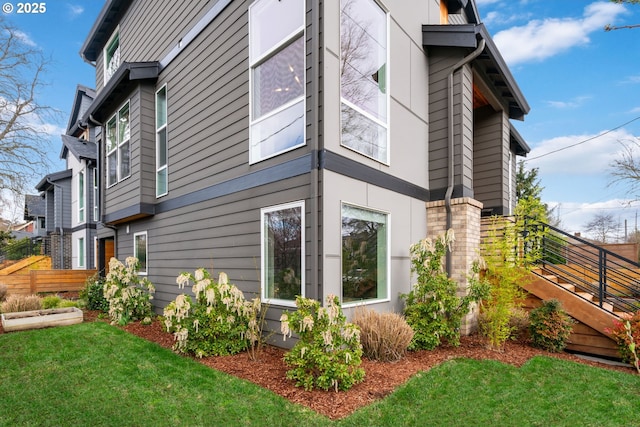 view of side of property with fence and a lawn