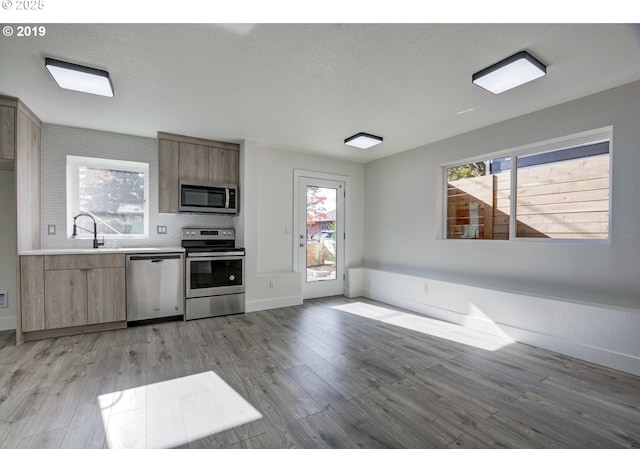 kitchen featuring a sink, light countertops, appliances with stainless steel finishes, and light wood-style floors