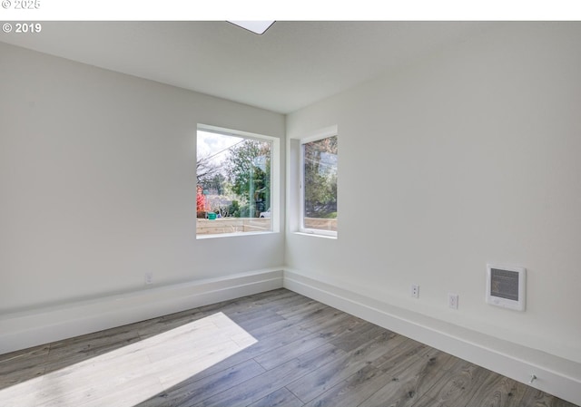 empty room featuring visible vents, baseboards, and wood finished floors