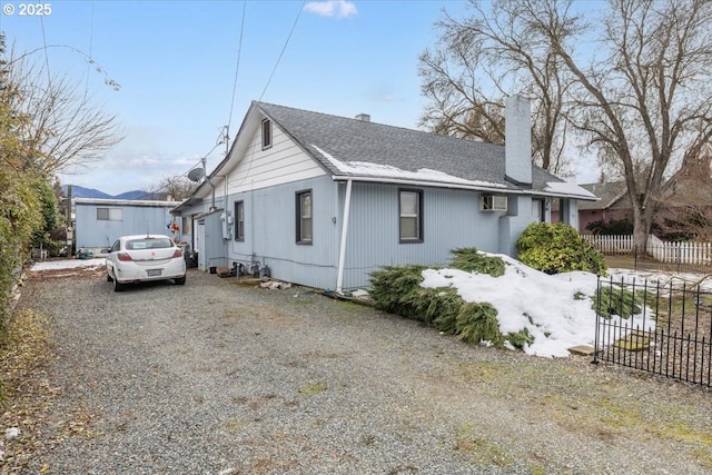 1711 Prune St, Medford, OR 97501 - view of home's exterior with gravel driveway, a shingled roof, fence, and a chimney