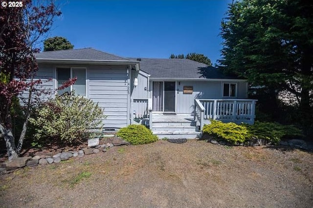 view of front facade featuring roof with shingles and crawl space