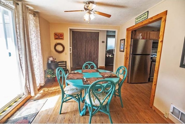 dining area with visible vents, plenty of natural light, and wood finished floors