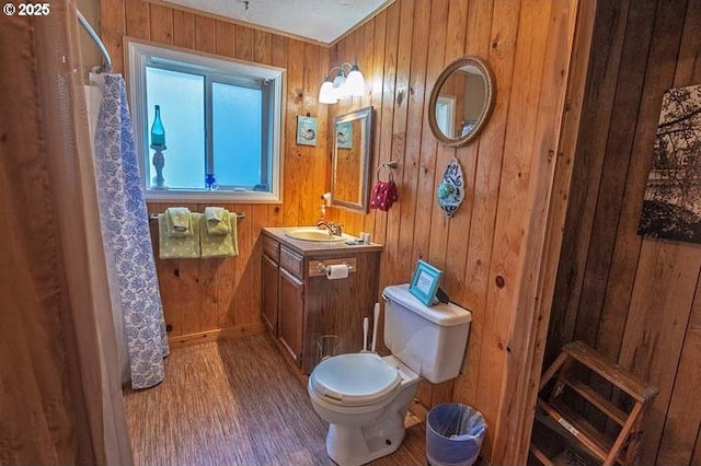 full bathroom featuring vanity, wood walls, baseboards, and toilet