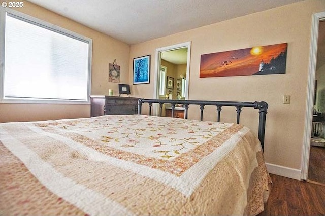 bedroom featuring baseboards and wood finished floors