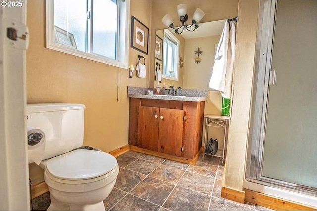 bathroom featuring vanity, baseboards, a shower stall, and toilet