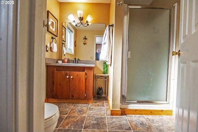 bathroom with vanity, toilet, a chandelier, and a stall shower
