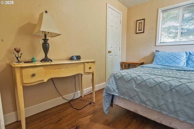 bedroom featuring baseboards and wood finished floors