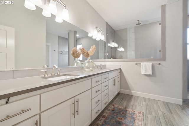full bathroom featuring double vanity, a sink, wood finished floors, and tiled shower
