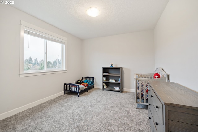 bedroom featuring baseboards, carpet flooring, and a textured ceiling