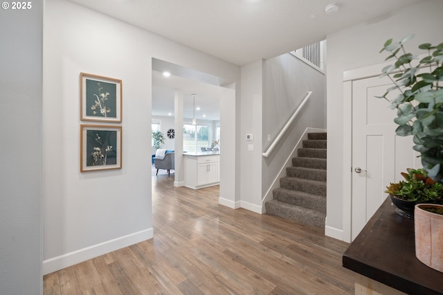 entrance foyer featuring recessed lighting, baseboards, stairs, and light wood-style flooring