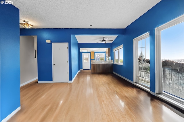 404 Chinook Ave, Astoria, OR 97103 - unfurnished living room with wood finished floors, baseboards, a textured ceiling, and a ceiling fan