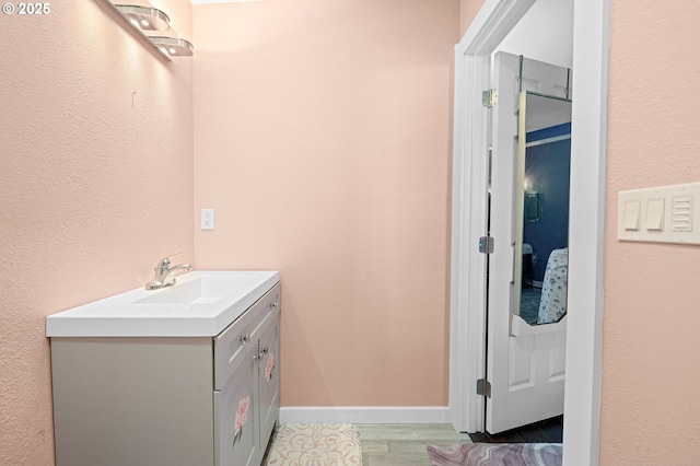 404 Chinook Ave, Astoria, OR 97103 - bathroom featuring vanity, a textured wall, wood finished floors, and baseboards