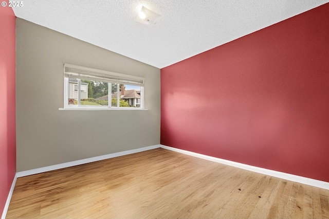 404 Chinook Ave, Astoria, OR 97103 - empty room with lofted ceiling, wood finished floors, a textured ceiling, and baseboards