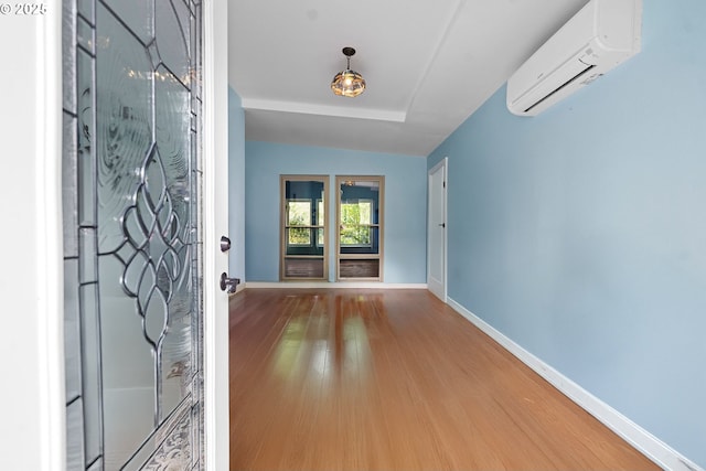 404 Chinook Ave, Astoria, OR 97103 - entryway with a wall unit AC, wood finished floors, baseboards, and vaulted ceiling
