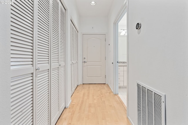 corridor featuring recessed lighting, visible vents, and light wood finished floors