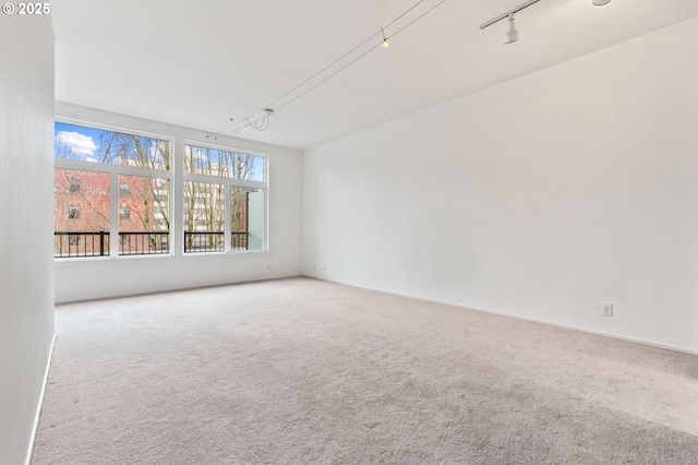 unfurnished room with rail lighting and carpet floors