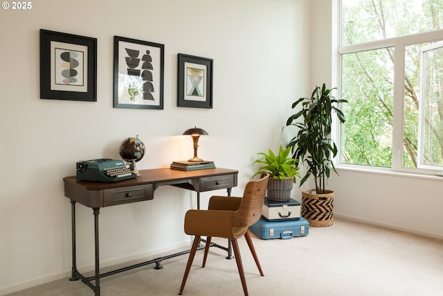 carpeted home office featuring baseboards