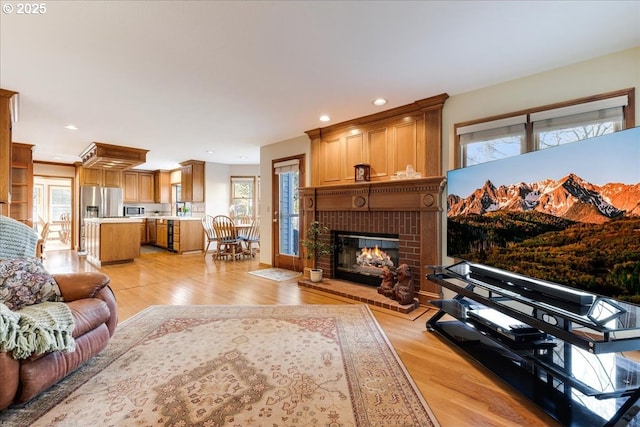 living room with a brick fireplace and light hardwood / wood-style flooring