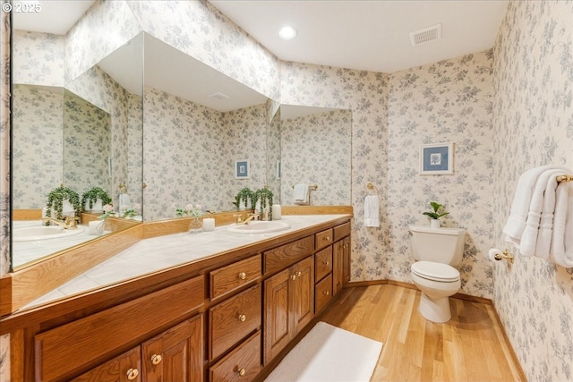 bathroom featuring wood-type flooring, toilet, and vanity