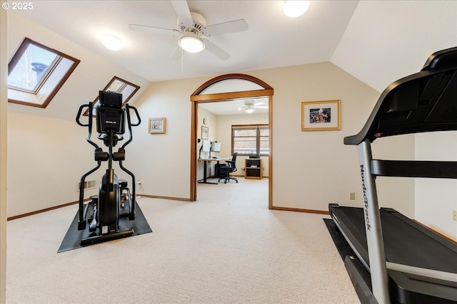 workout area with ceiling fan, lofted ceiling with skylight, and carpet floors