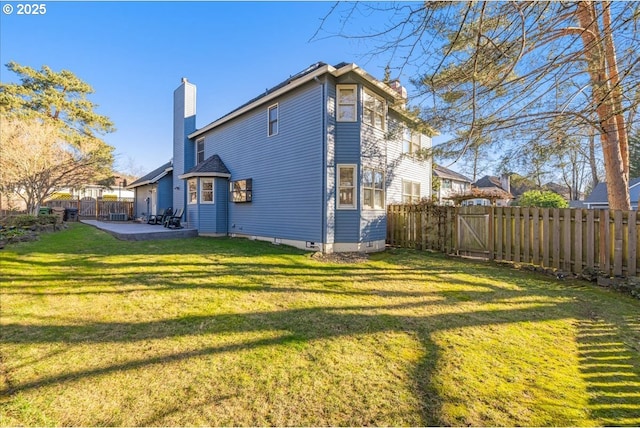 rear view of property with a yard and a patio area