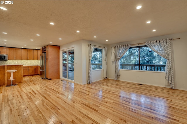 unfurnished dining area featuring recessed lighting, visible vents, light wood-type flooring, and baseboards