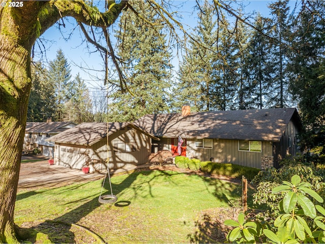 view of front of home with a chimney, a front lawn, and an attached garage