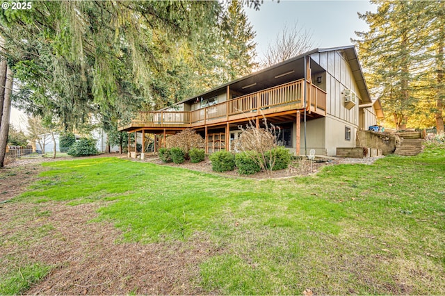 back of property featuring a wooden deck, fence, a yard, and board and batten siding