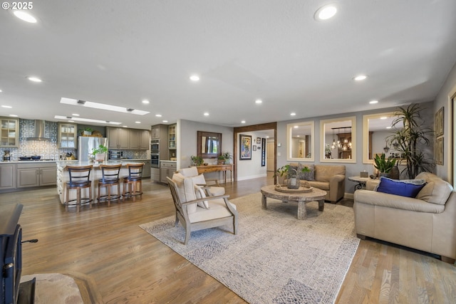 living room featuring recessed lighting, light wood-type flooring, and baseboards