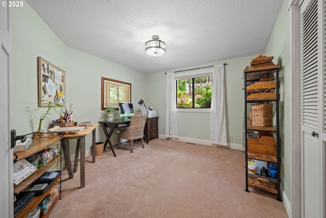 office area featuring light colored carpet, baseboards, and a textured ceiling