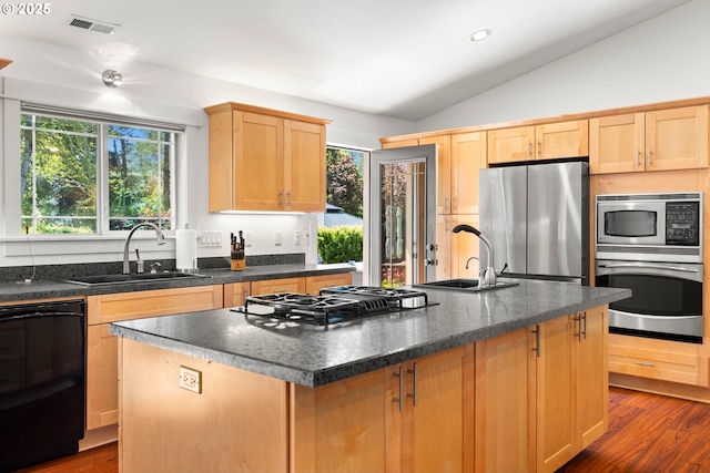 kitchen featuring a sink, lofted ceiling, light brown cabinetry, and black appliances