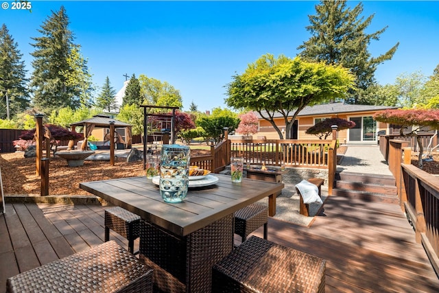 wooden deck featuring outdoor dining area and a gazebo