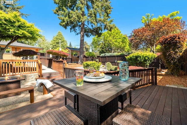 wooden deck with outdoor dining space and a fenced backyard