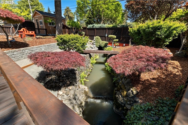 view of yard with an outdoor structure, a storage shed, and a fenced backyard