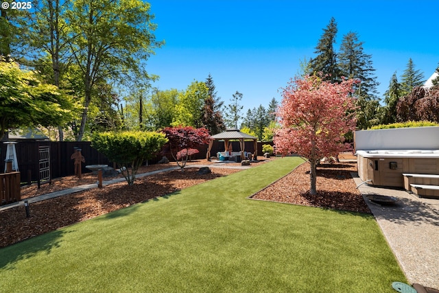 view of yard featuring a gazebo, a patio area, a hot tub, and fence