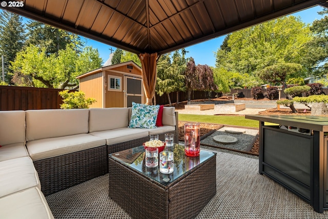 view of patio / terrace with a storage shed, an outbuilding, a fenced backyard, outdoor lounge area, and a vegetable garden