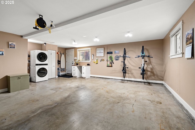 garage with stacked washer / dryer and baseboards