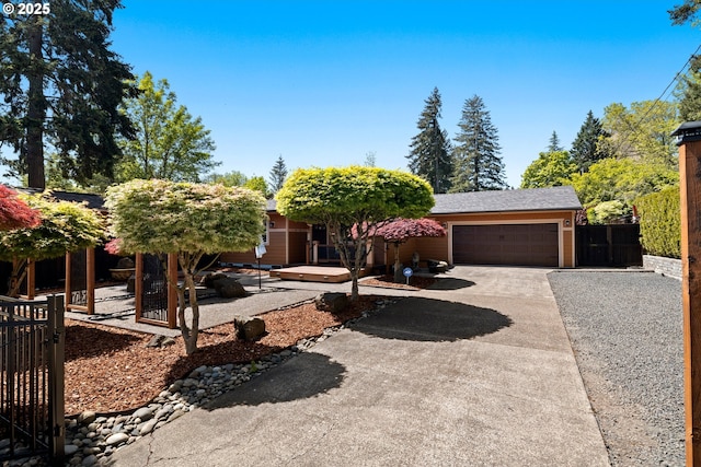 view of front facade featuring a gate, concrete driveway, a garage, and fence