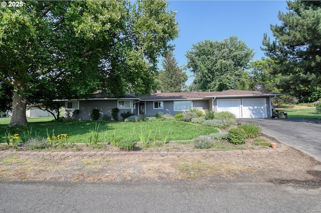 ranch-style home featuring driveway, a front yard, and a garage