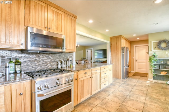 kitchen featuring light brown cabinetry, backsplash, appliances with stainless steel finishes, and light stone countertops