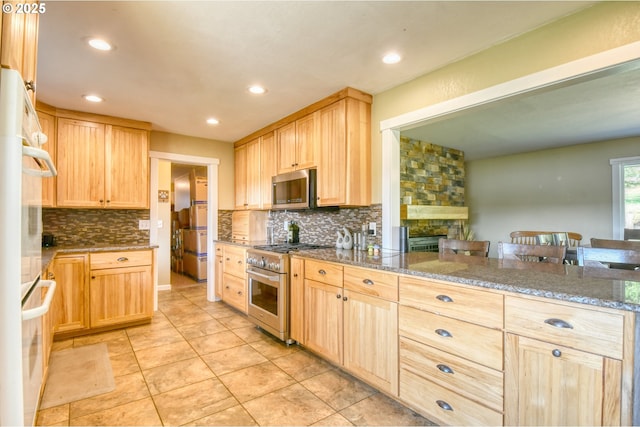 kitchen featuring tasteful backsplash, light brown cabinetry, stone counters, recessed lighting, and stainless steel appliances