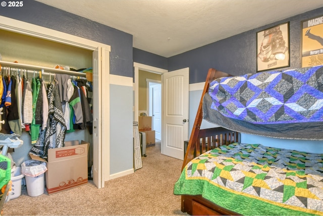 bedroom featuring carpet, a closet, and a textured wall